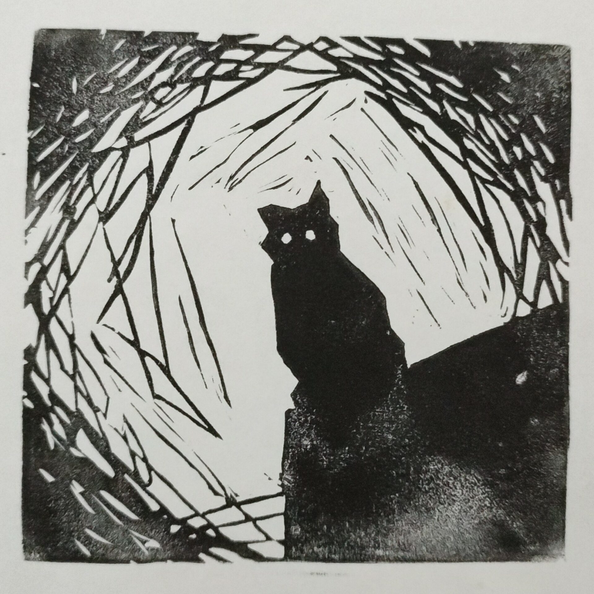 Foto a una lámina estampada en color negro sobre papel blanco, de una gata. La gata está en la equina inferior derecha, con unos ojos completamente blancos, sobre una superficie sin definir que tiene debajo. La gata y la superficie sobre la que se posa ocupan algo más que del cuarto inferior derecho de la lámina, quedando los ojos de esta casi en la mitad de la lámina. Los trazos son toscos, sin curvas, todo líneas rectas (a excepción de los agujeros redondos de los ojos). La imagen se ha hecho para que se plasme un gran viñeteado en las esquinas, pasando del blanco al negro, a base de menos a más condensación de líneas. El estampado del color es desigual, mostrando distinta carga de color por una presión no uniforme. La composición tiene algo inquietante.