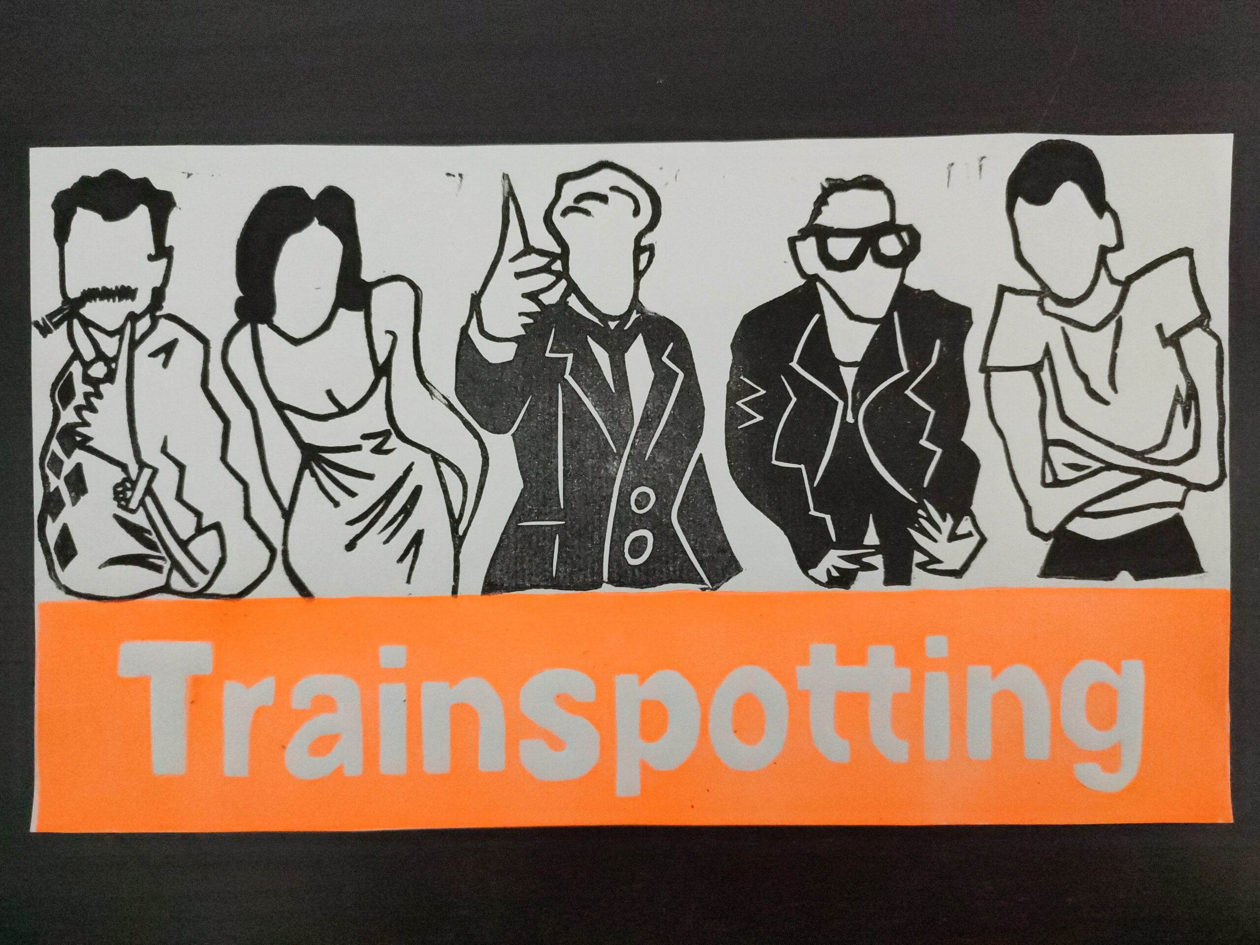 Lámina impresa versioneando el cartel de la película Trainspotting sobre un fondo negro. El dibujo es apaisado, en el que salen, en el tercio inferior de la imagen, la palabra "Trainspotting" en letras gruesas y blancas sobre fondo naranja y brillante; y en los dos tercios de arriba, cinco de los protas de la película, todos con un dibujo sencillo, de trazo grueso y líneas irregulares y con poco detalle (las caras ni siquiera tienen ojos, nariz o boca). Los dibujos son en blanco y negro De izquierda a derecha salen: Robert Carlyle, de lado, con el brazo izquierdo por delante y doblado, enseñando los dedos corazón e índice (signo que se usa en Inglaterra a modo de reto, no tiene que ver con la victoria). Tiene en esa mano una pulsera de eslabones y un anillo grande. Tiene un bigote "de cuñado", del que sale un cigarro encendido, y un jersey de rombos negros. Kelly Macdonald aparece inclinada hacia adelante, acercando la cara, con las manos cogidas por la espalda a la altura del culo. Lleva un vestido de tirantes muy finos. Jonny Lee Miller aparece en el centro, lleva un traje negro con camisa blanca y corbata. Aparece hinchando ligeramente el pecho, con el brazo derecho extendido terminando en una mano que hace el gesto de ser una pistola con los dedos pulgar, índice y corazón. Ewen Bremner tiene una pose también hacia adelante, acercando, similiar a la de Kelly, pero en su caso tiene las manos por delante en un gesto que parece acompañar a algo que está tratando de explicar. Viste pantalón y chaqueta negra, con una camiseta blanca. En la cabeza se ven unas gruesas gafas de ver, de montura de pasta. A la derecha del todo sale Ewan McGregor, tiene los brazos cruzados delante del pecho, con los dedos metidos casi dentro de los sobacos, el gesto es un poco encogido (no está pasando un buen momento). Leva unos pantalones negros y una camiseta blanca. En la lámina se aprecia la rugosidad del papel, así como se ven algunos desperfectos en el estampado (alguna mancha negra, y un ligero desfase entre la parte de los personajes y la de las letras).